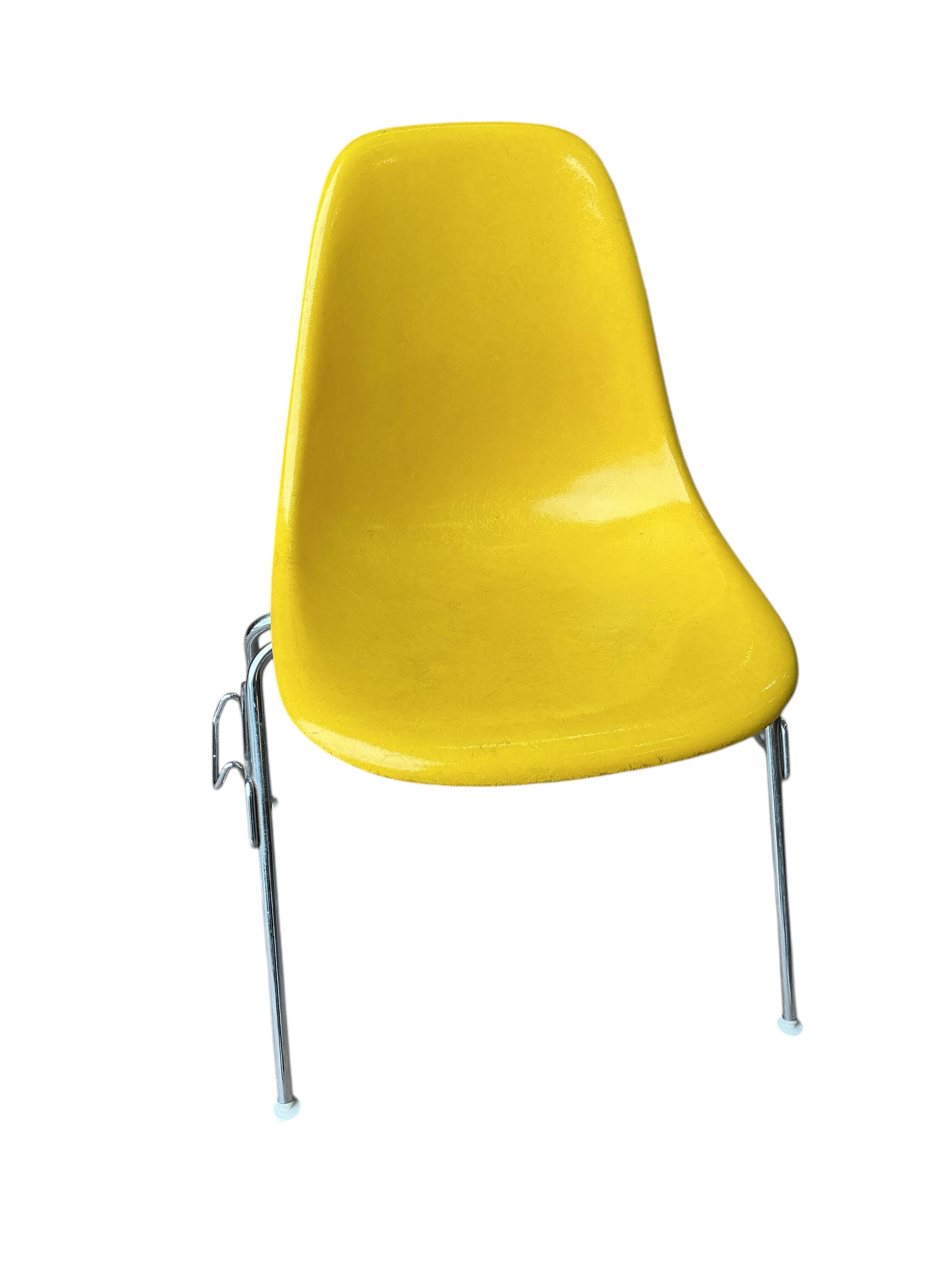 A set of four yellow and chrome Eames shell chairs, width 58cm, height 80cm